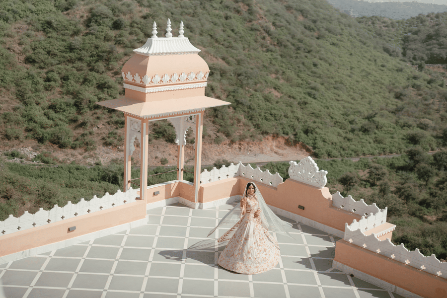 The newly wed couple dancing on a terrace of Fateh Vilas, Udaipur surrounded by green hills.