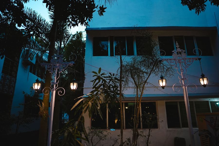 An facade image of Rangamati Garden Resort featuring two storey building with lamps style lights lit on the pathway 