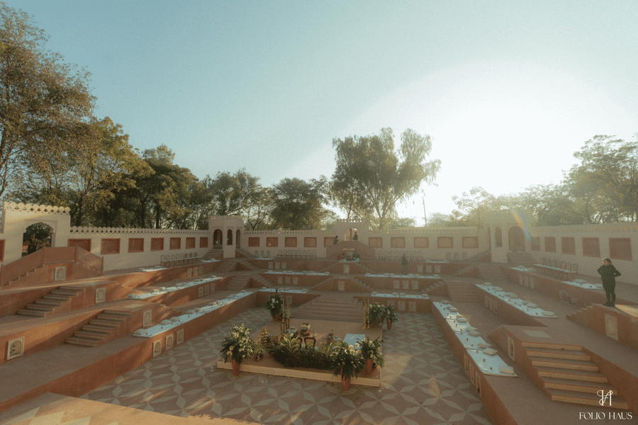 A wide-angle view of an expansive, traditional stepped stone courtyard and amphitheater structure at Umaid Palace.