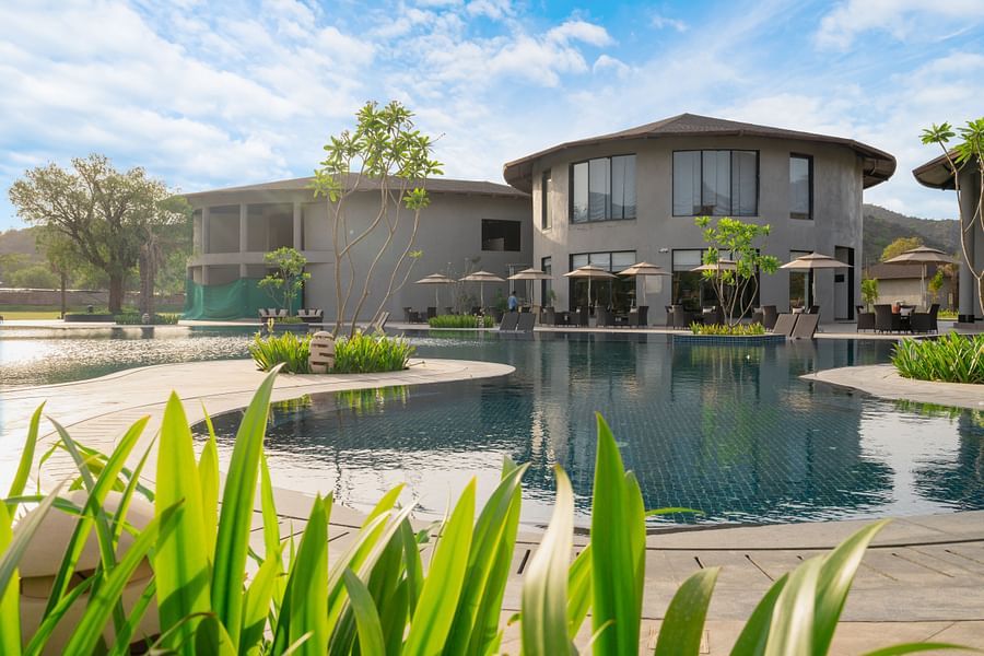 View of a villa at Ananta Spa and Resort, Ajabgarh from the pool under a blue sky