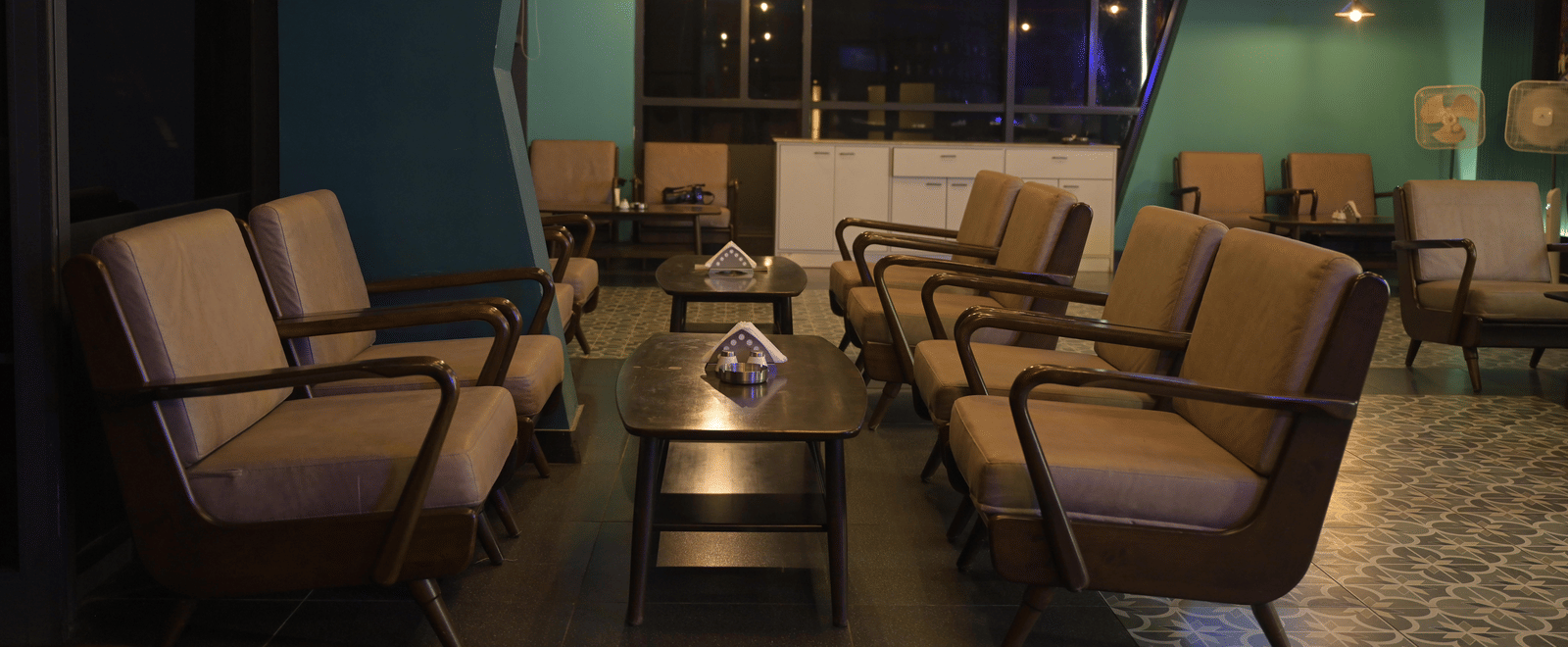 A relaxed seating corner with sofas and a central table under soft evening lighting at Hotel Sonar Bangla Mayapur.