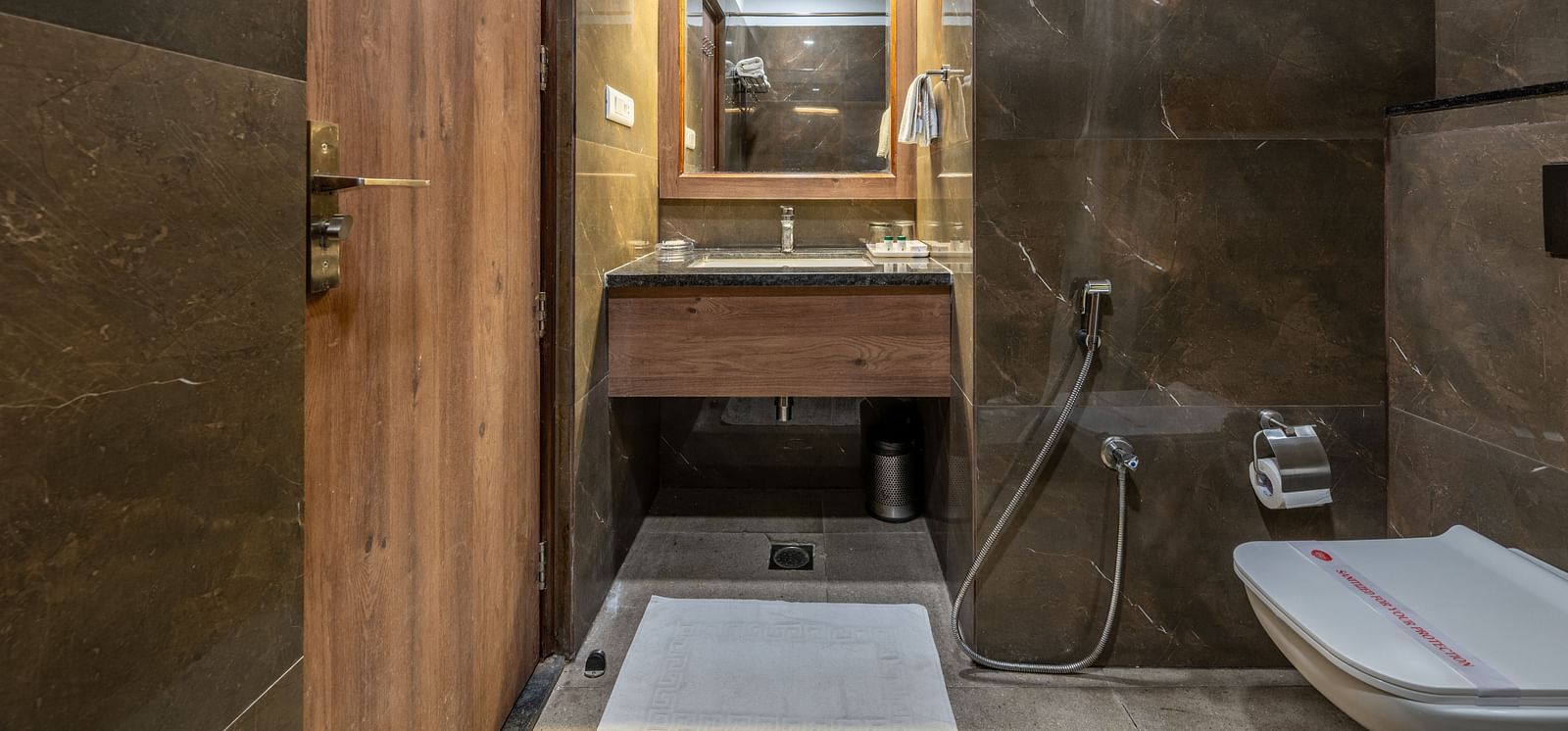 Contemporary bathroom with vanity, mirror, and shower enclosure at Hotel Highway King, Bilaspur.