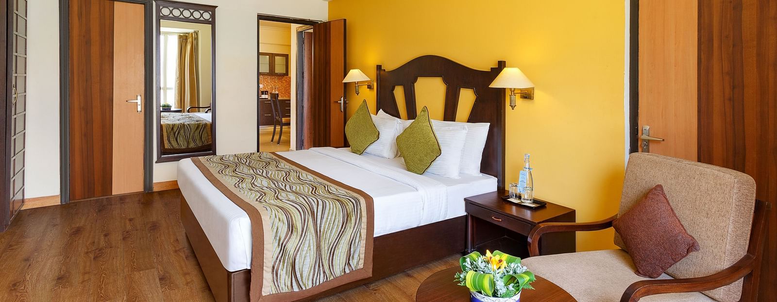 This image showcases a luxurious hotel room of aloha on the ganges, with a warm and inviting atmosphere. The room features a large king-size bed with a plush headboard and comfortable bedding.