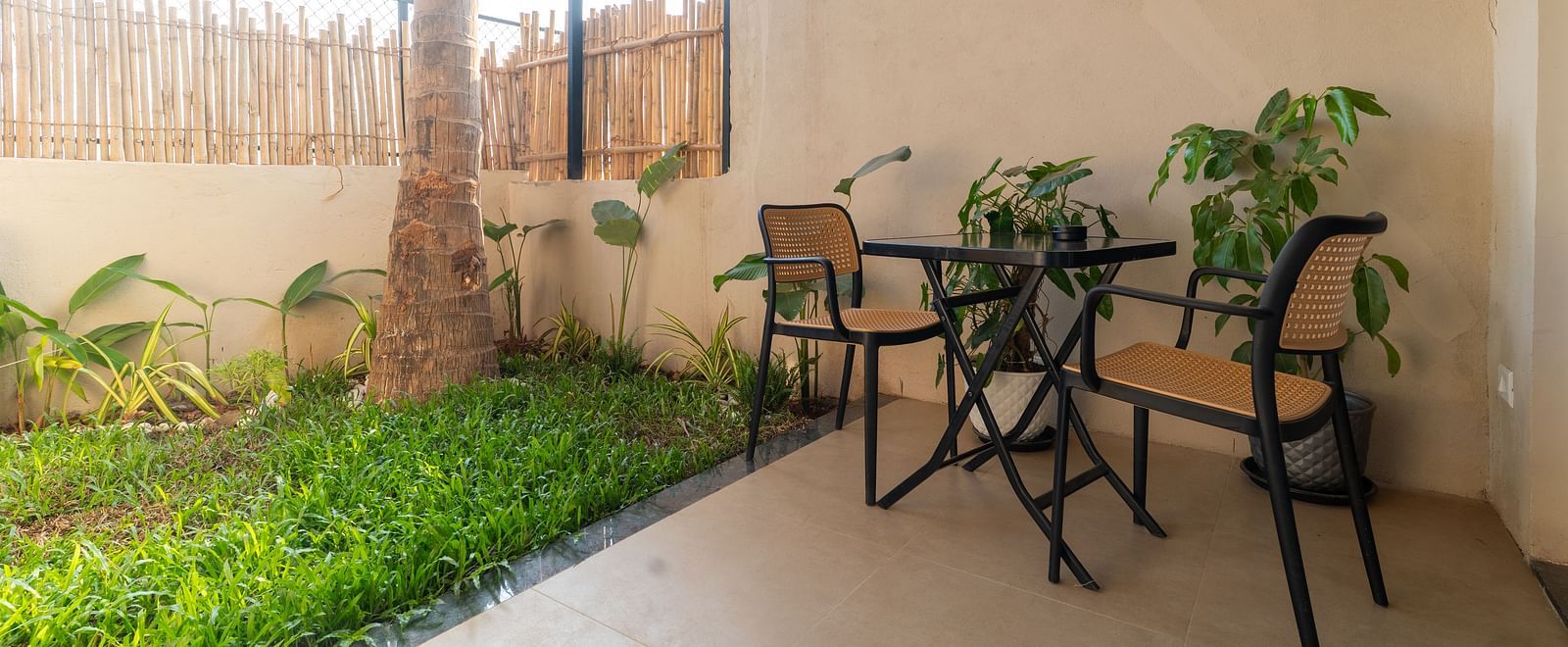 Charming private garden patio with table and chairs surrounded by greenery at Kssemya.