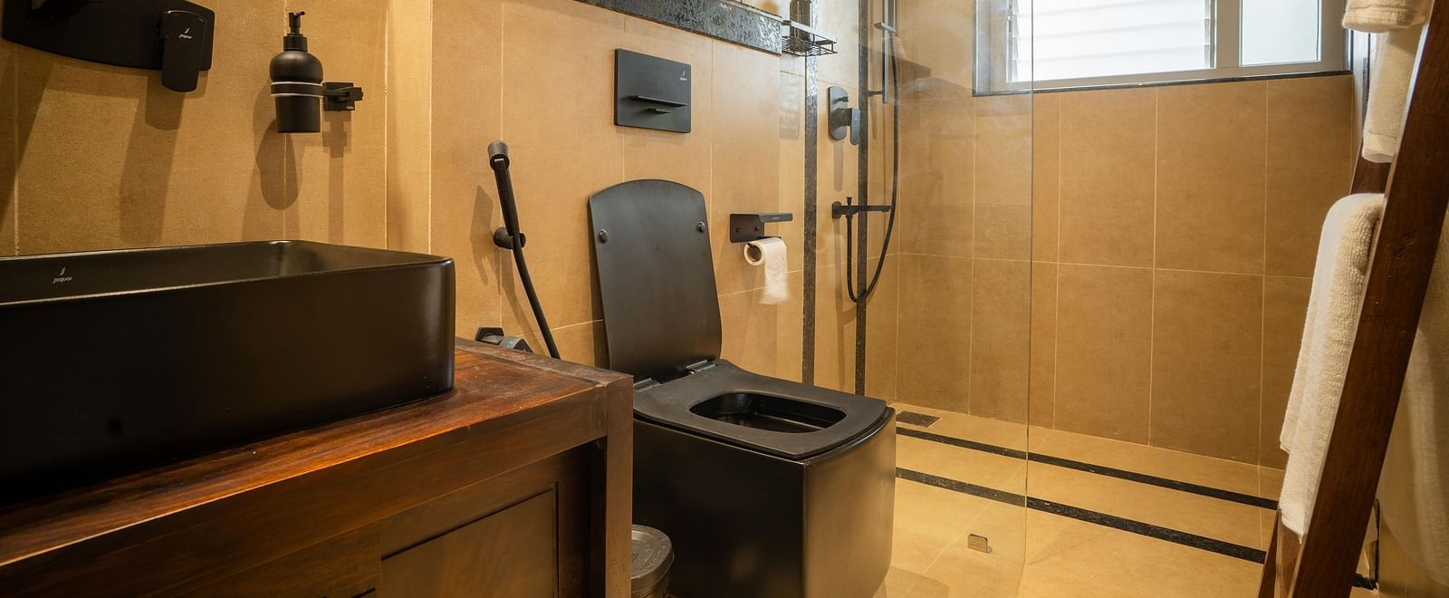 Bathroom with stylish black fixtures and warm wooden cabinetry at Kssemya.