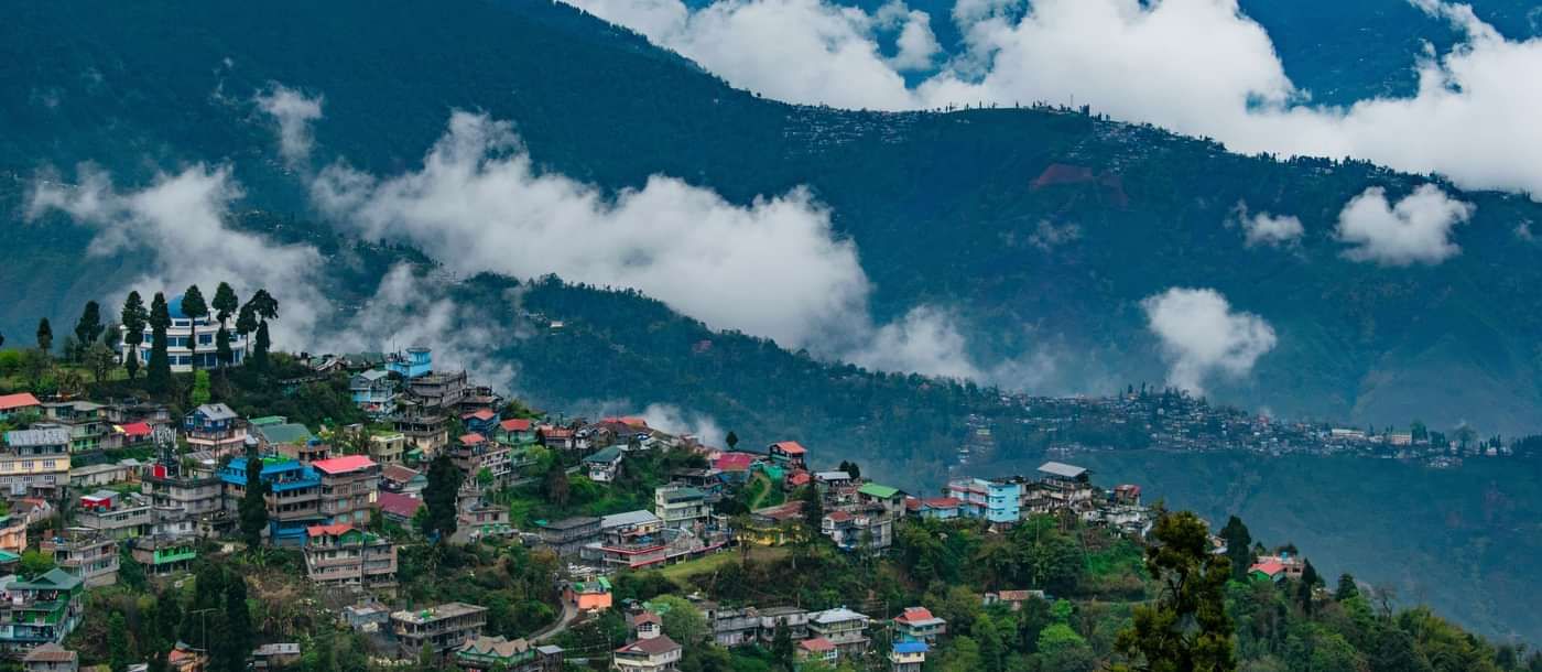 Hills near Summit Hotels and Resorts covered with mist and it also shows a residential areas.