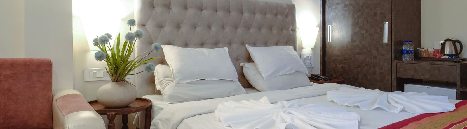 A cosy bedroom featuring a padded headboard, bed, and warm lighting – The Verda de Miranda Resort.