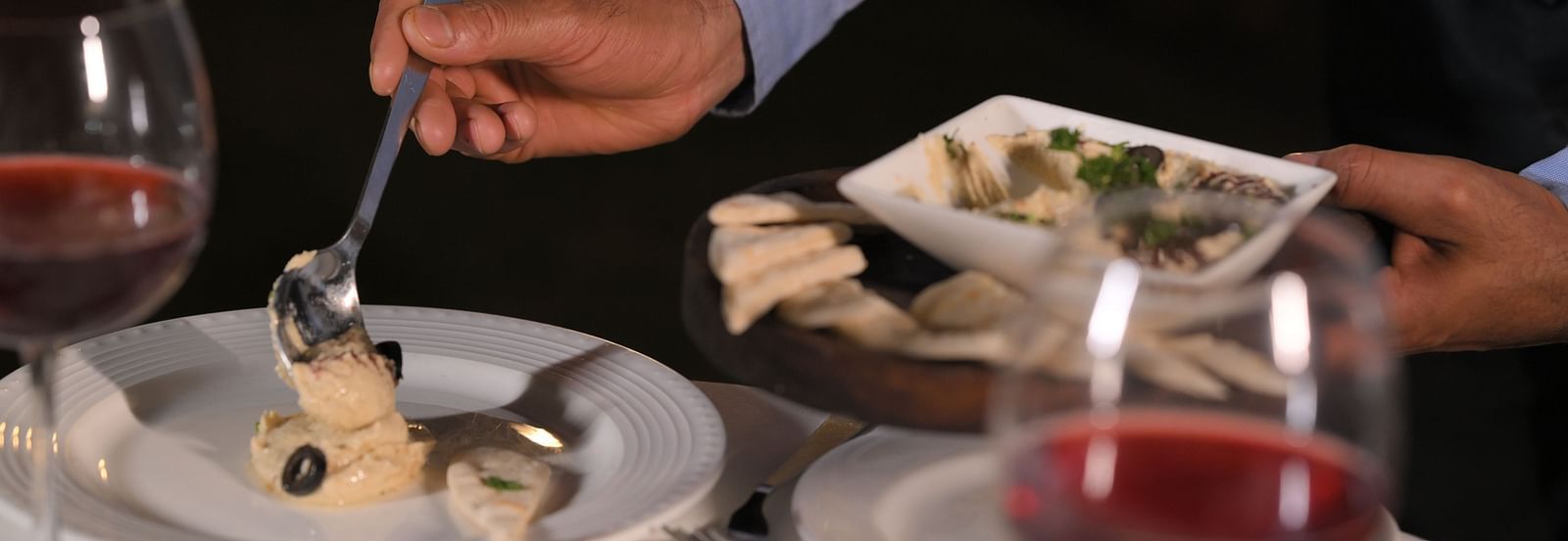 Guest being served a fine dining dish at Royal Comfort Regency with wine, showcasing personalised service and attention to detail.
