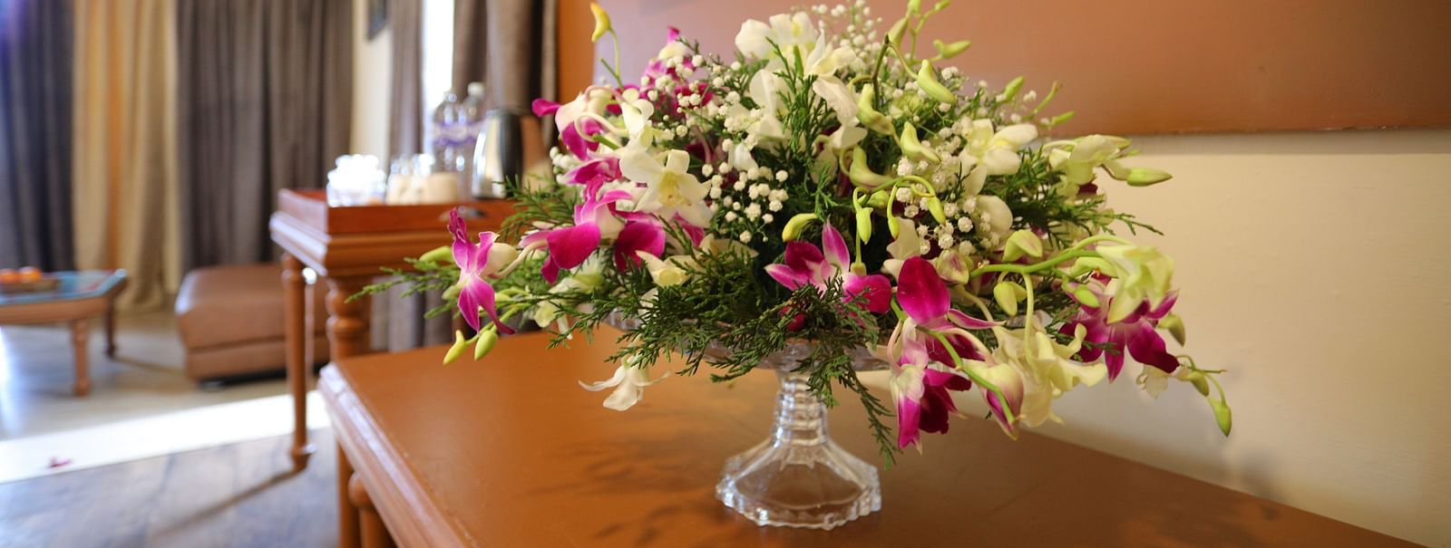 a glass vase placed with flowers at La Montana By TGI, Ooty