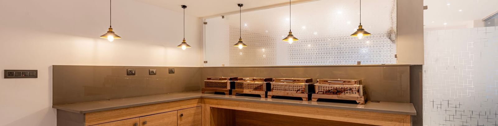 A modern buffet area wooden counter and contemporary pendant lighting - Beestay Hotels Financial District, Hyderabad 