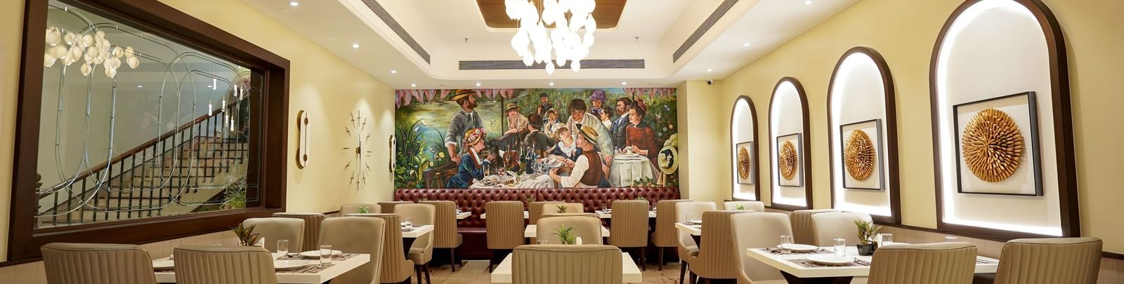 A full view of the Mosaic restaurant featuring a modern chandelier hanging from the ceiling illuminating the entire dining area at M2 Square by Monday Premium.