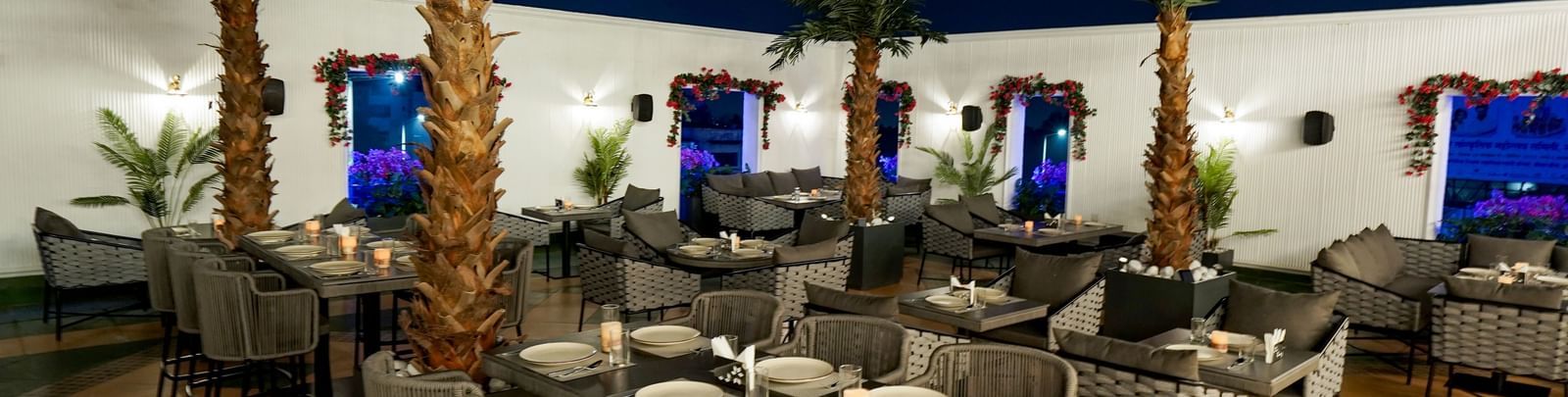 Corner view shot of the Sky Roof featuring well arranged dining tables along side several trees at M2 Square by Monday Premium.