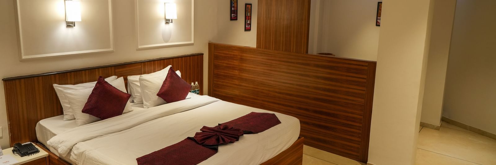 Spacious guest room with a large double bed and modern interiors at Pravasa Hotel Kolhapur.