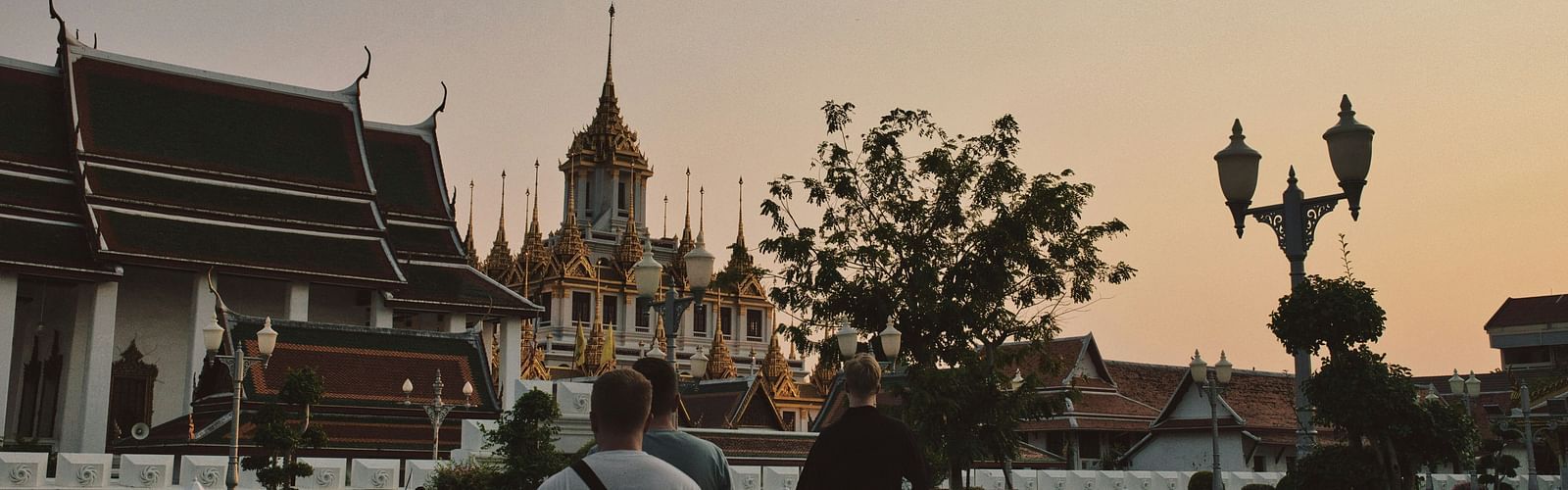 an overview of a temple in bangkok with people walking towards it.
