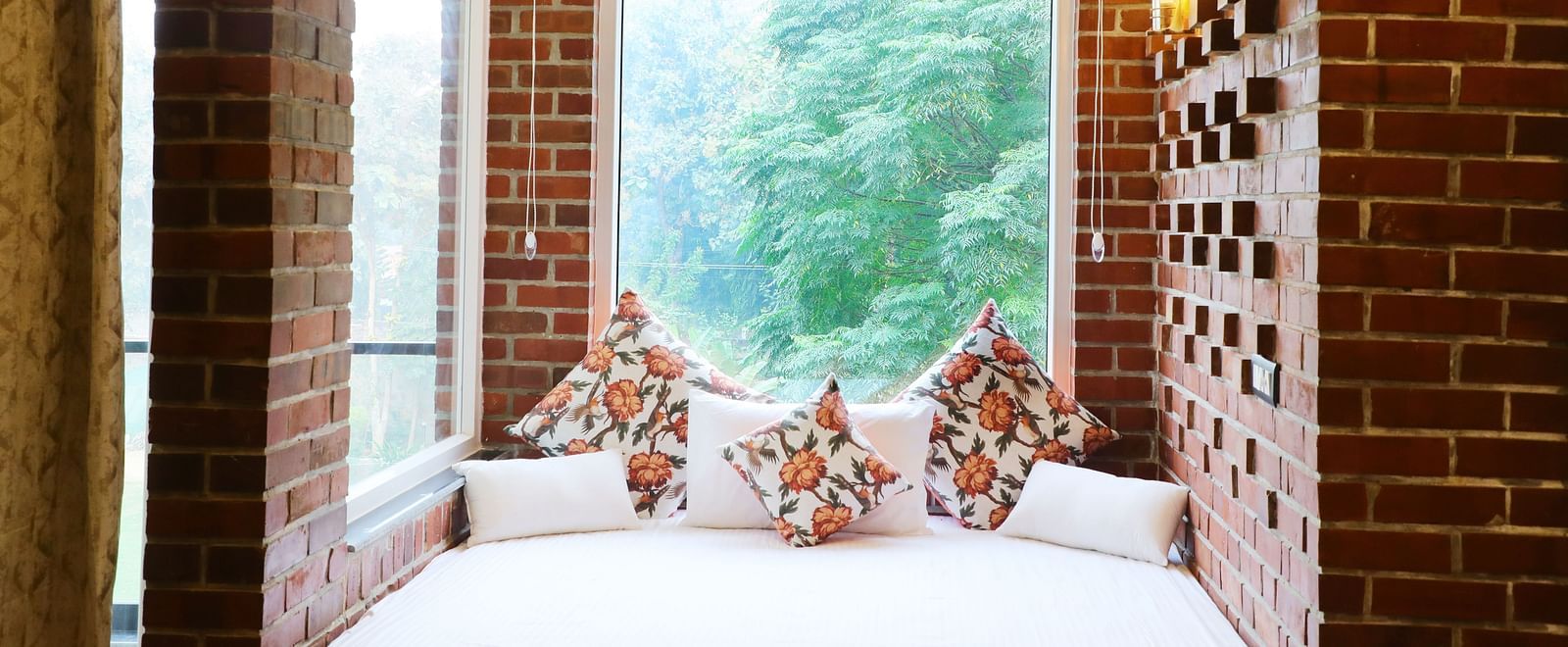 Niche bed space set into an arched brick alcove with pillows at Tisya Farms, Gurgaon.