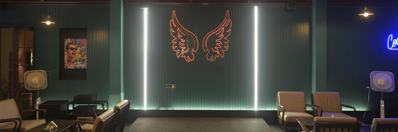 Front-facing view of the lounge bar with a lit butterfly artwork and comfortable seating arranged neatly at Hotel Sonar Bangla Mayapur.