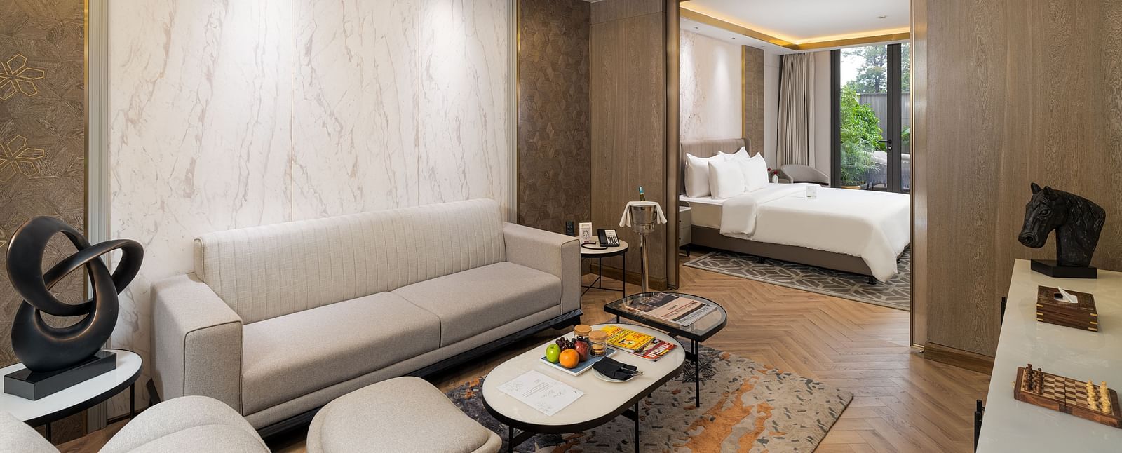 Nirvana Suite living area with a stylish sofa, a chic coffee table, and an open view into the spacious bedroom - Nirvana Luxury Hotel, Ludhiana