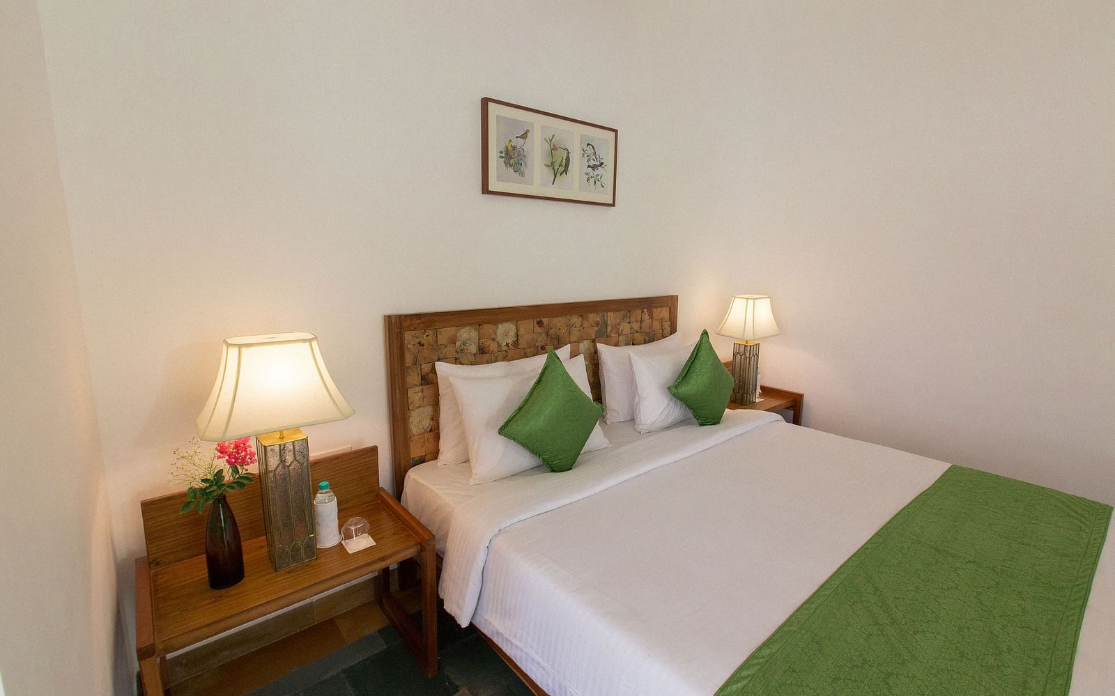 A room at Saraca Resort & Spa Corbett with a double bed and side tables with bed lamps placed on top of them