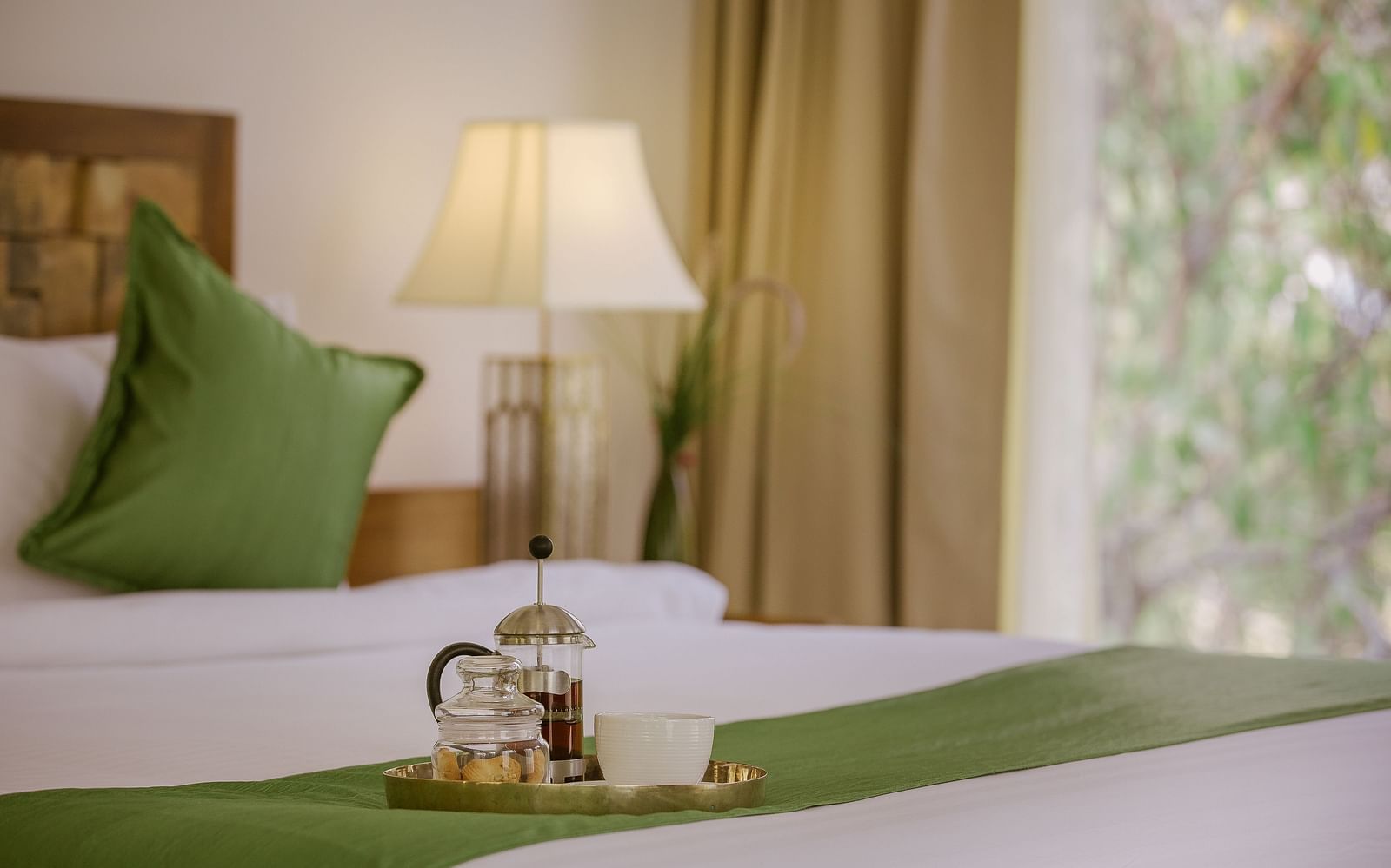 A tray with coffee placed on the bed in a room at Saraca Resort & Spa Corbett