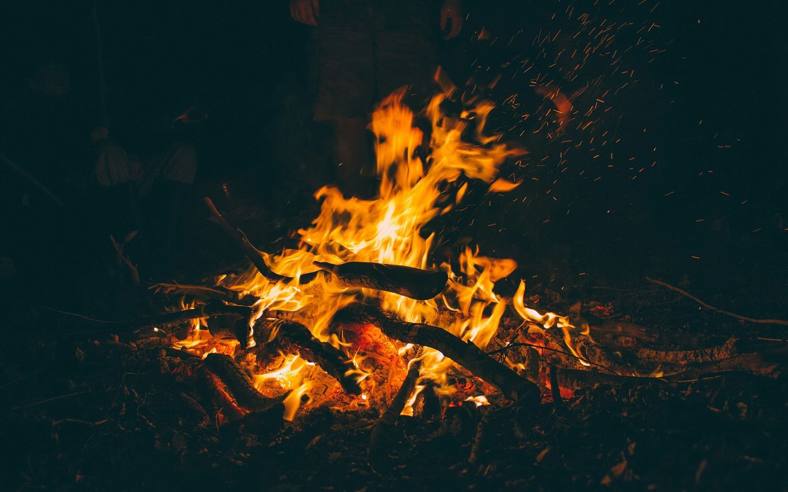 A close up shot of a bonfire in the night with the fire raging