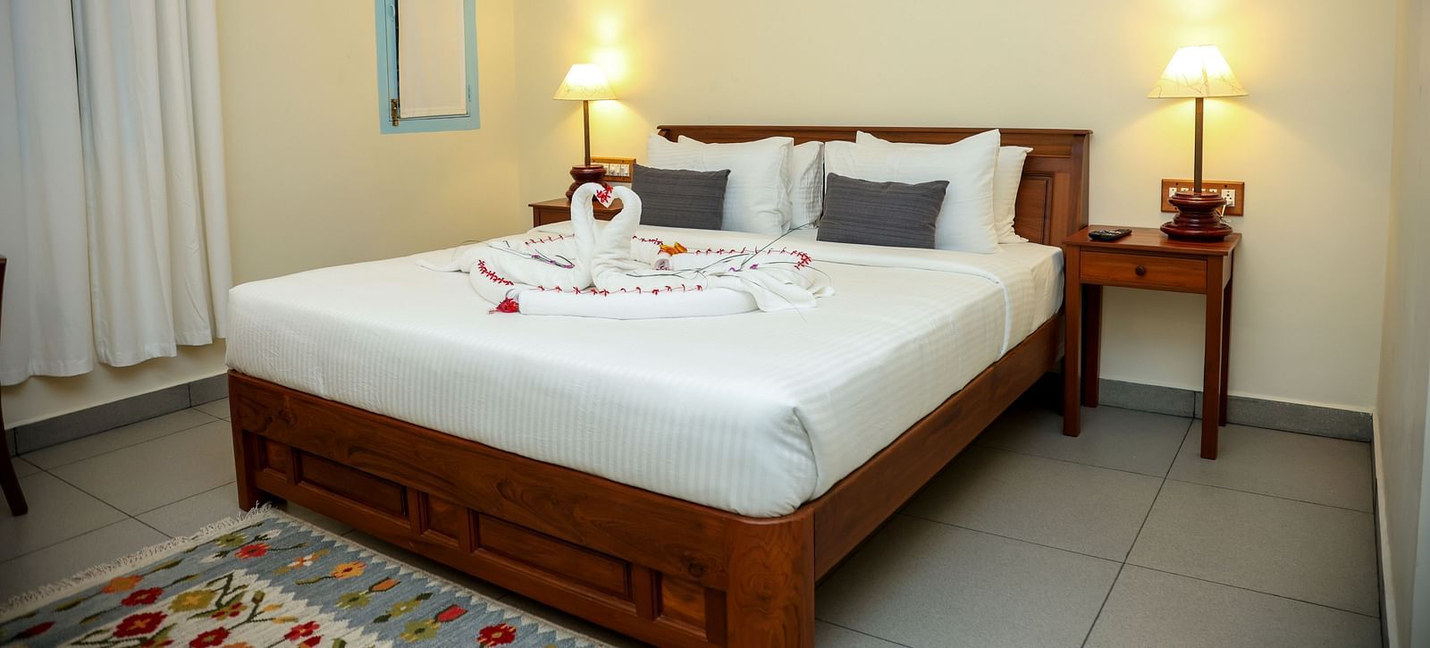 A bedroom which has a bed decorated by towel swans | Mango Hill La Serene, Pondicherry