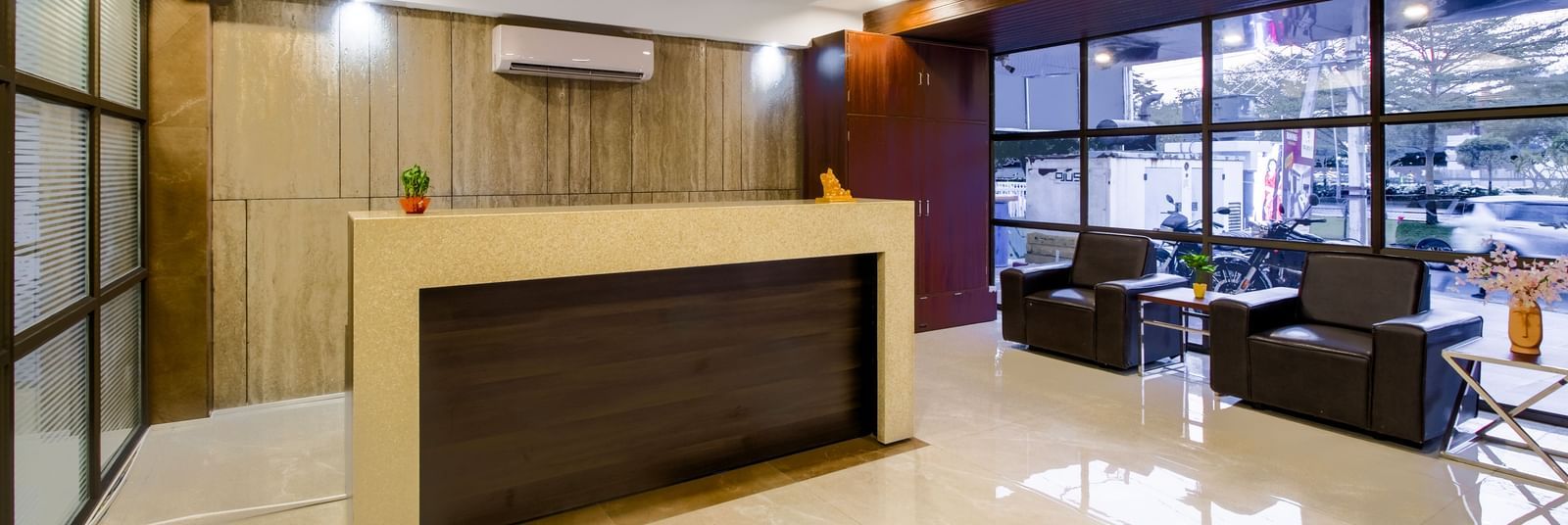 Reception desk with seating area polished flooring and contemporary design at Swarna's The Capital.