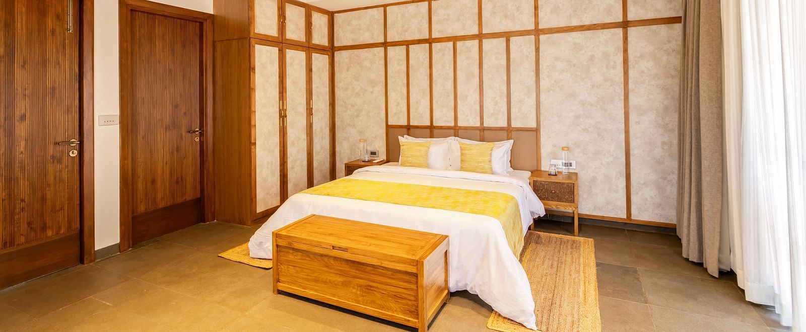 A spacious bedroom with a pitched wooden ceiling, a king-sized bed, and minimal yet elegant decor - BluSalzz Villas - Alocassia, Anjuna