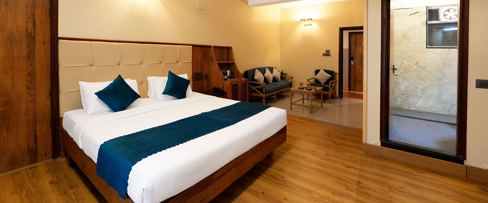 An Executive Room with a queen size bed, a seating area, a bathroom, and stylish decor - Cross Roads Inn, Bengaluru