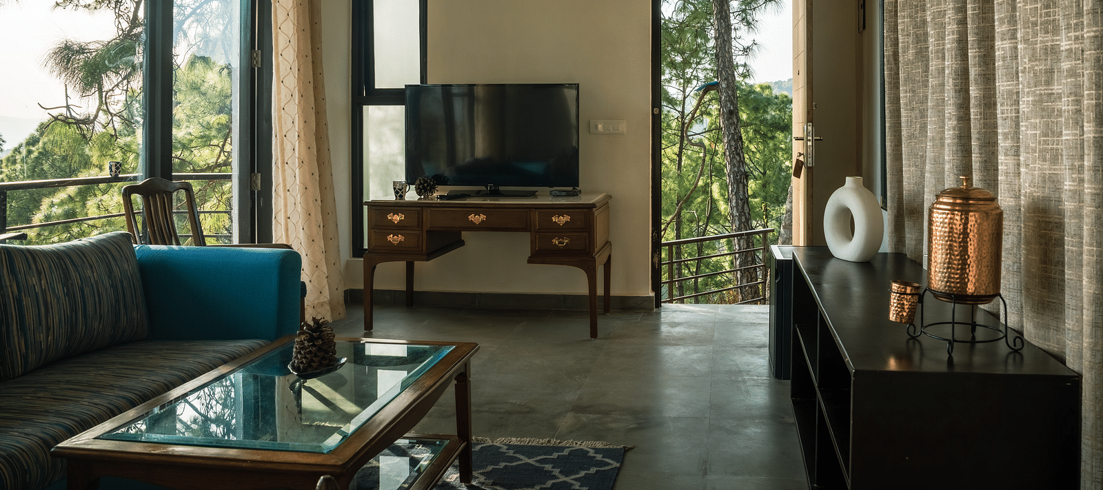 A living room featuring sofas, a table, and a television at BluSalzz Escapade Resort, Lansdowne