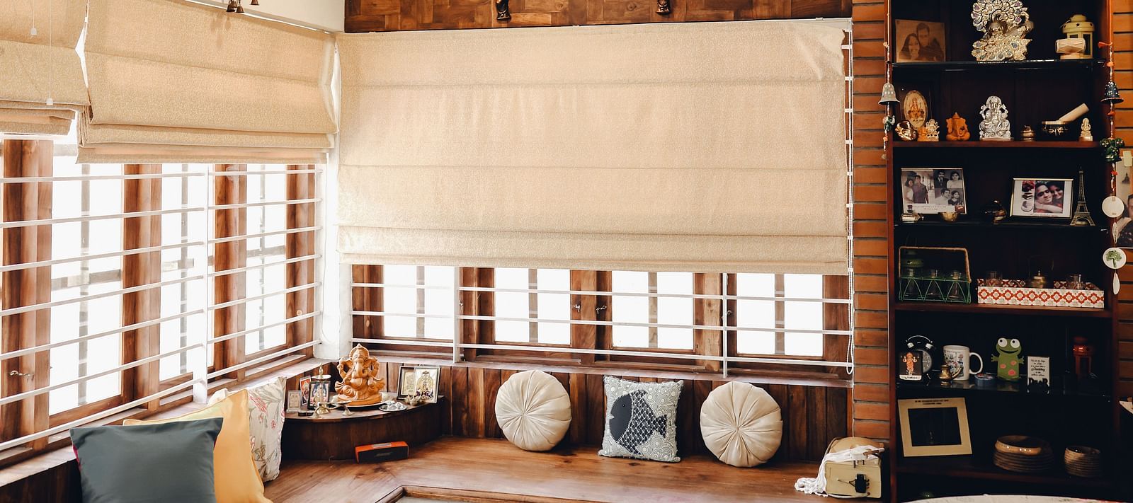a large l-shaped sofa and a shelf with things kept in the Living Room at Ananda Holiday Home, Wayanad