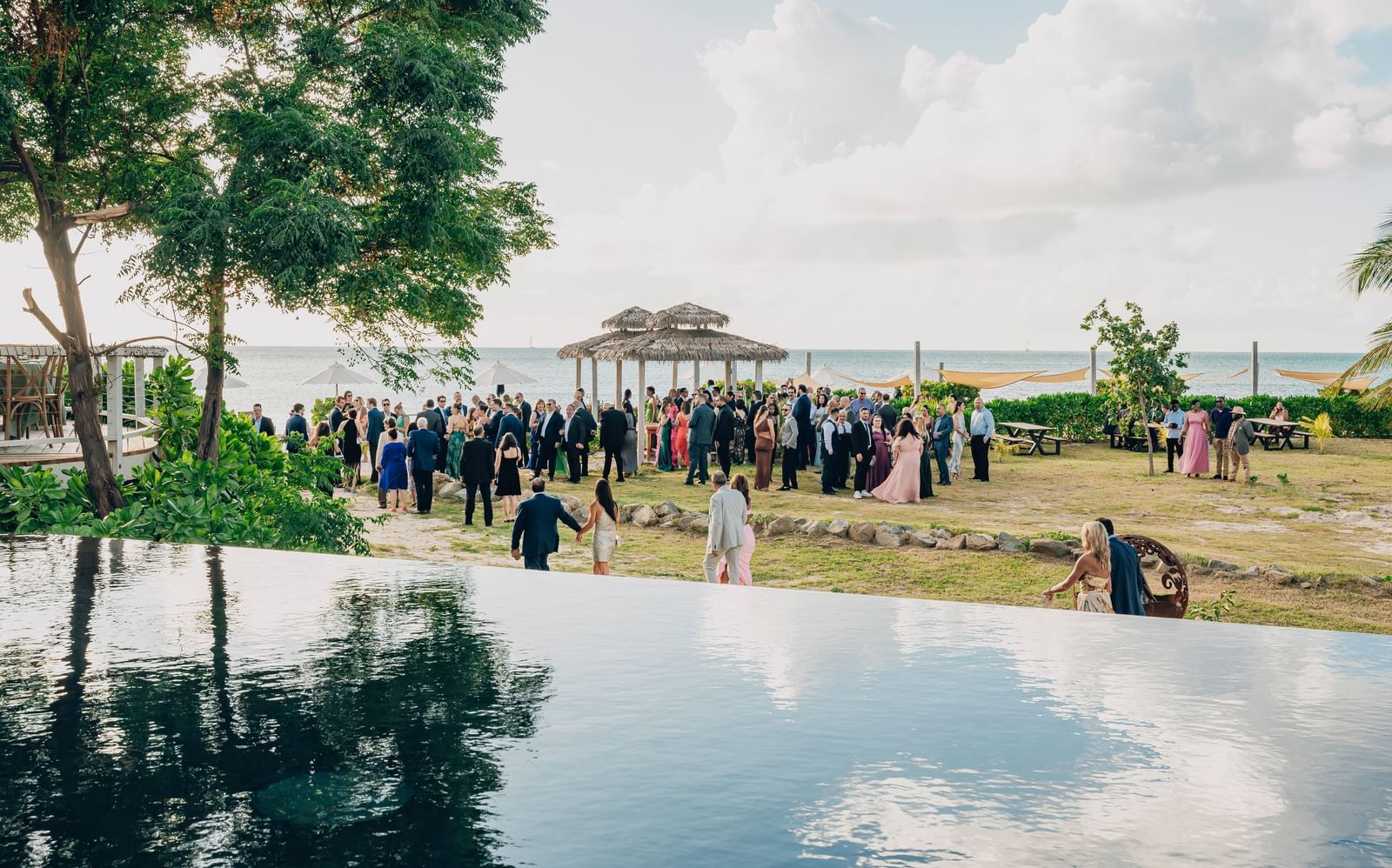 A scenic outdoor event space with pool view at Tamarind Hills Resort and Villas, Antigua set up for a wedding or gathering.