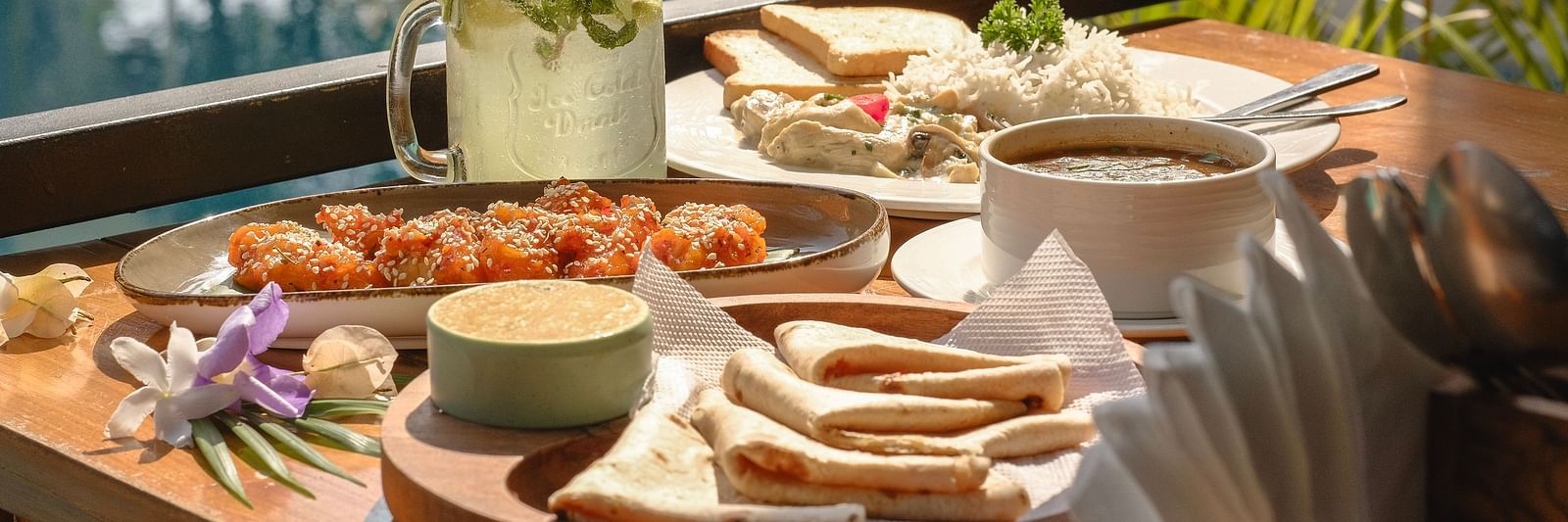 Close-up of assorted appetisers, dips, and drinks served poolside at The Verda de Miranda Resort.