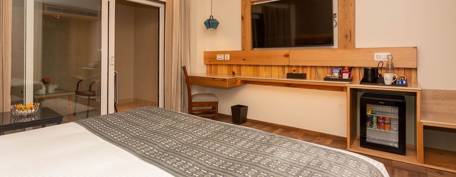 An image of a Deluxe Room with a bed, flat screen TV, work desk and chair - The Belvedere Himalayan Retreat, McLeodganj