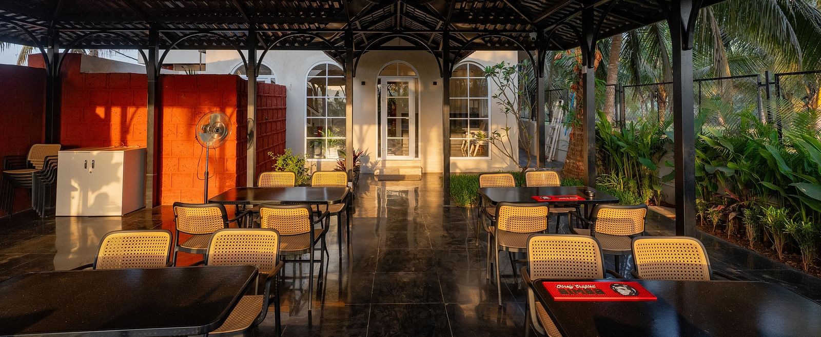 A partially enclosed outdoor dining area with a dark, peaked roof at Kssemya.
