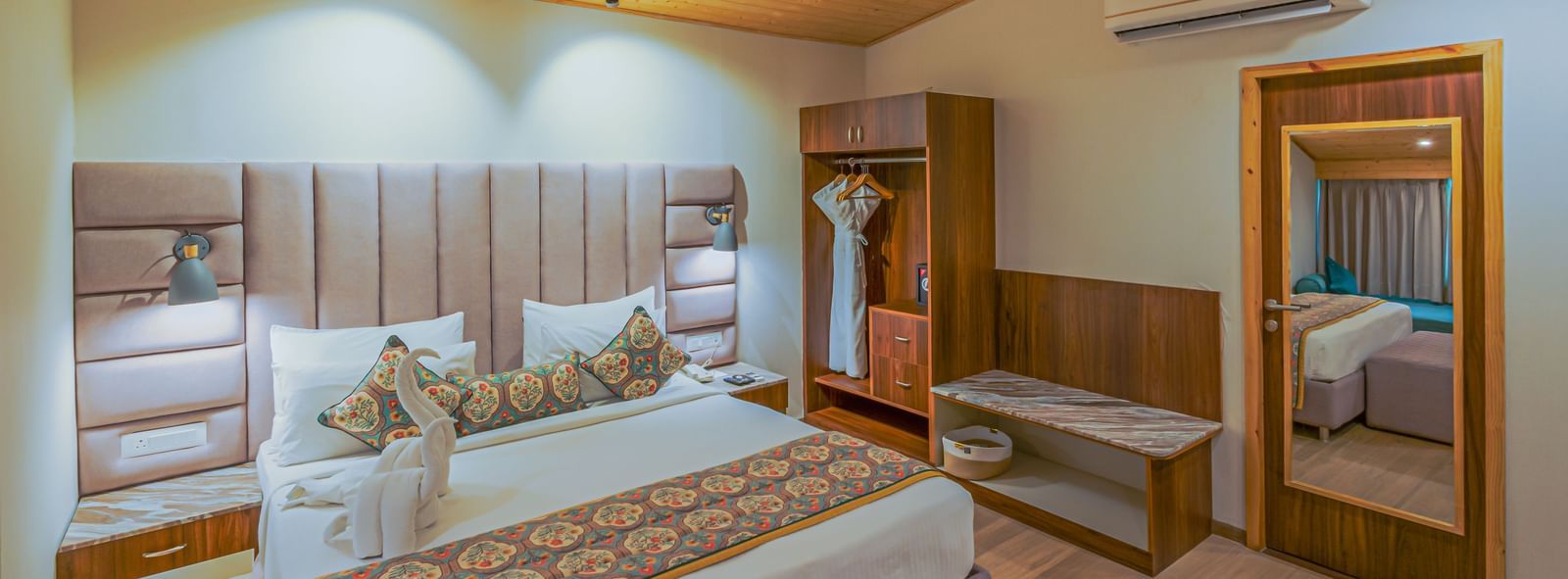 Sajjan Villa at Bamboo Saa  Resort and Spa featuring a double sized bed, a wardrobe, and a mirror attached on the door.