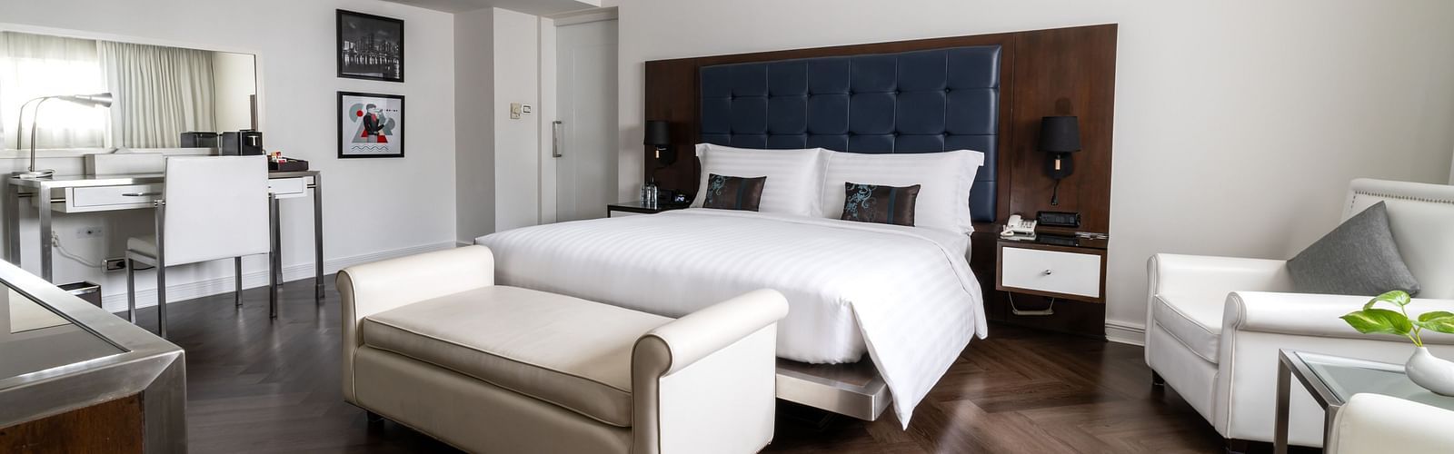 A king bed with a small sofa in front of it inside one of the rooms - Night Hotel Bangkok