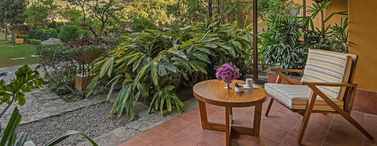 An image featuring outdoor sitting area with a table and chair, set against a backdrop of stunning mountain views.