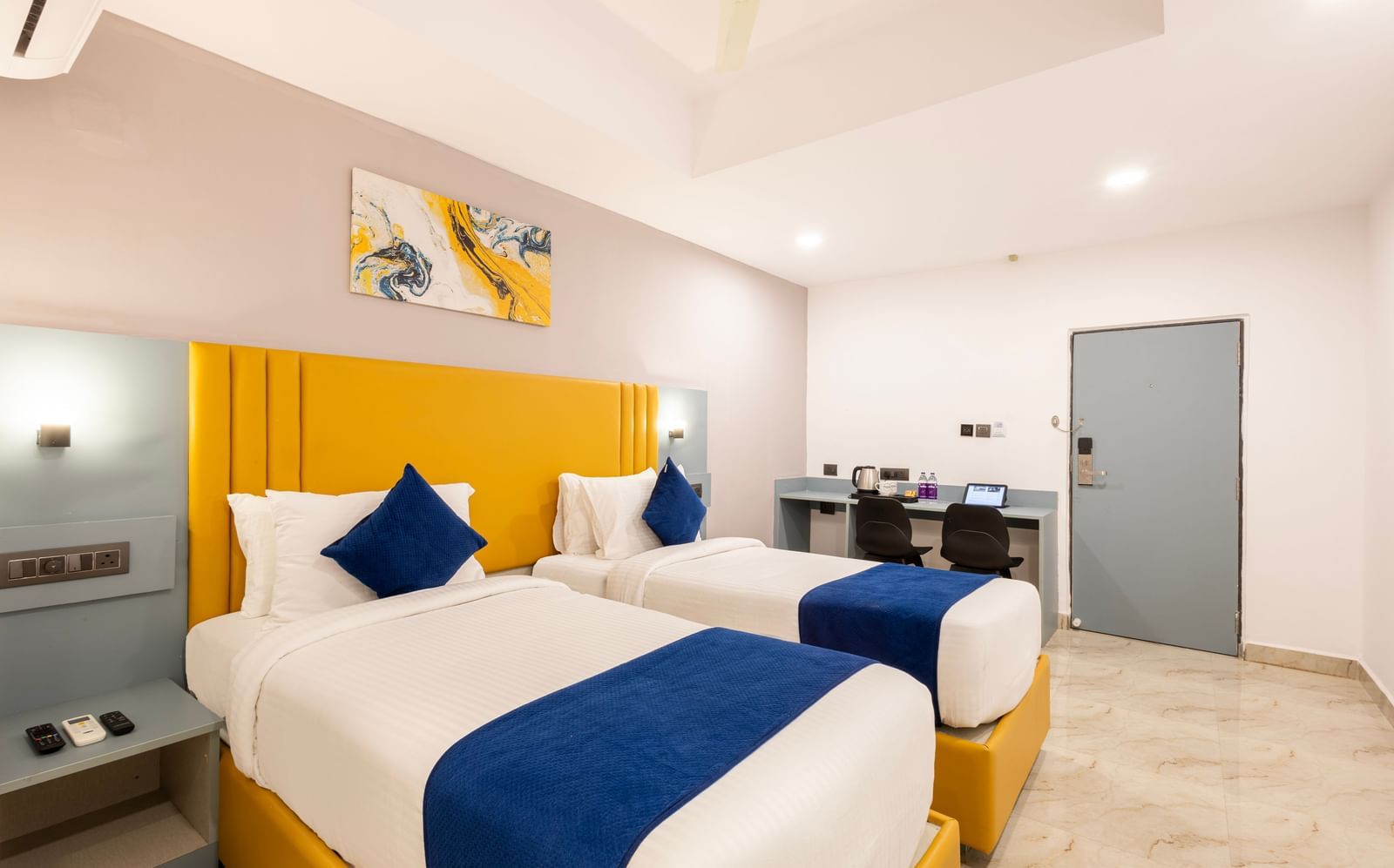 Full view of Superior Room featuring a bed with blue and white bedding, a yellow headboard, and modern furnishings including a desk and TV - Beestay Hotel Financial District, Hyderabad