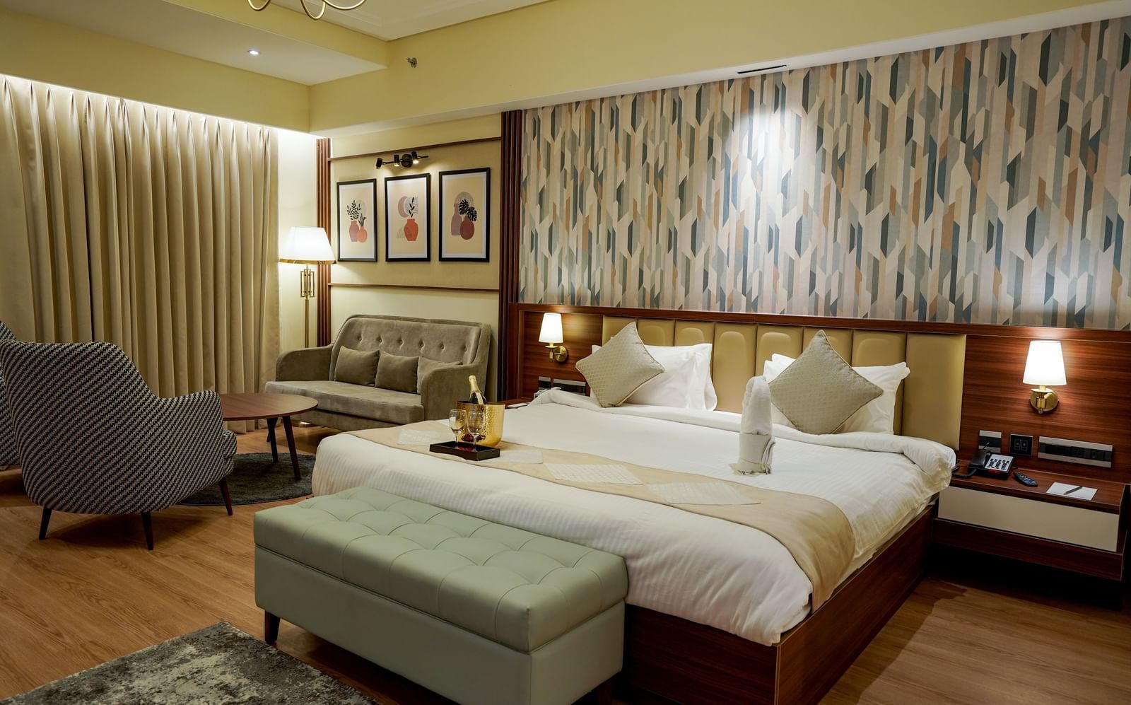 Corner view of the double bed in the Premium Room along with a common seating area in the corner of the room at M2 Square by Monday Premium.