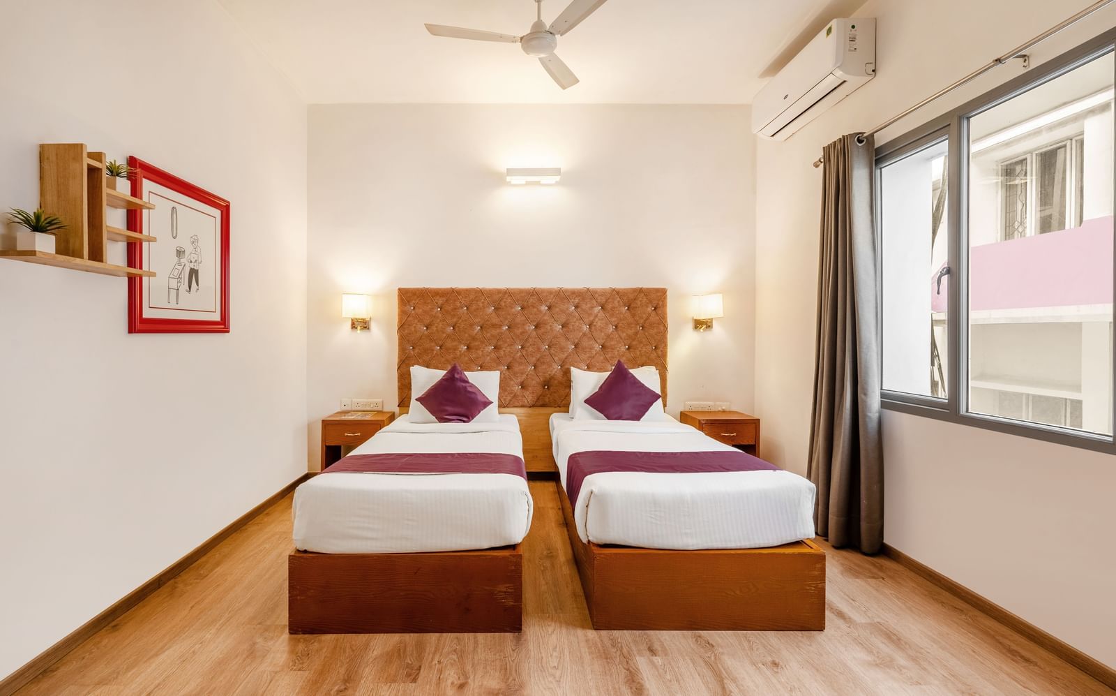 A hotel room with 2 single beds. a ceiling fan and a large window with the curtains opened - Monday Hotels HITEC City, Hyderabad