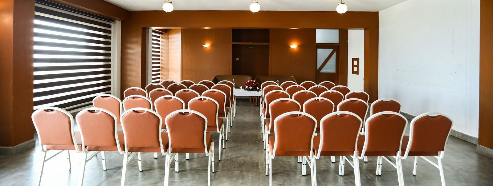 brown and white chairs placed in the banquet hall of La Montana By TGI, Ooty
