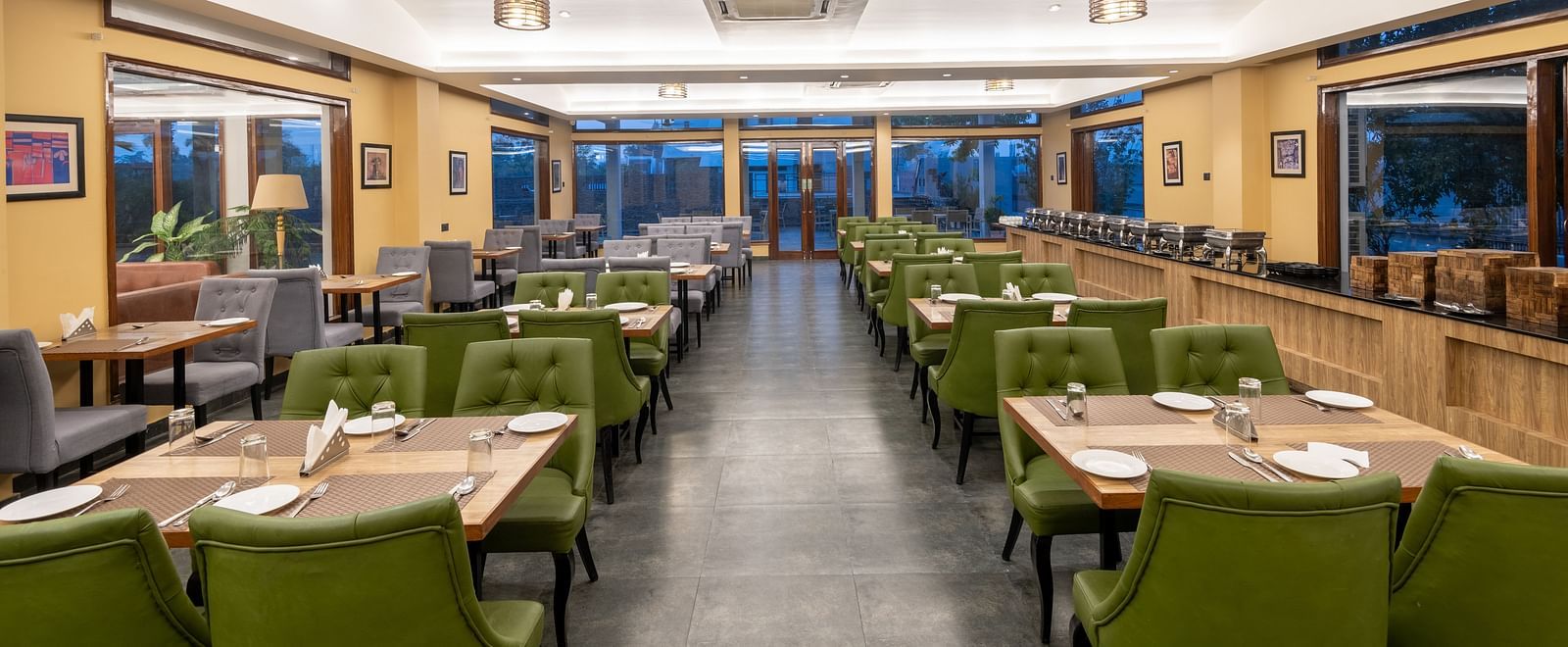 View from one end of the dining area at DLS Forest Vines Resort, with tables and chairs neatly set on both sides.