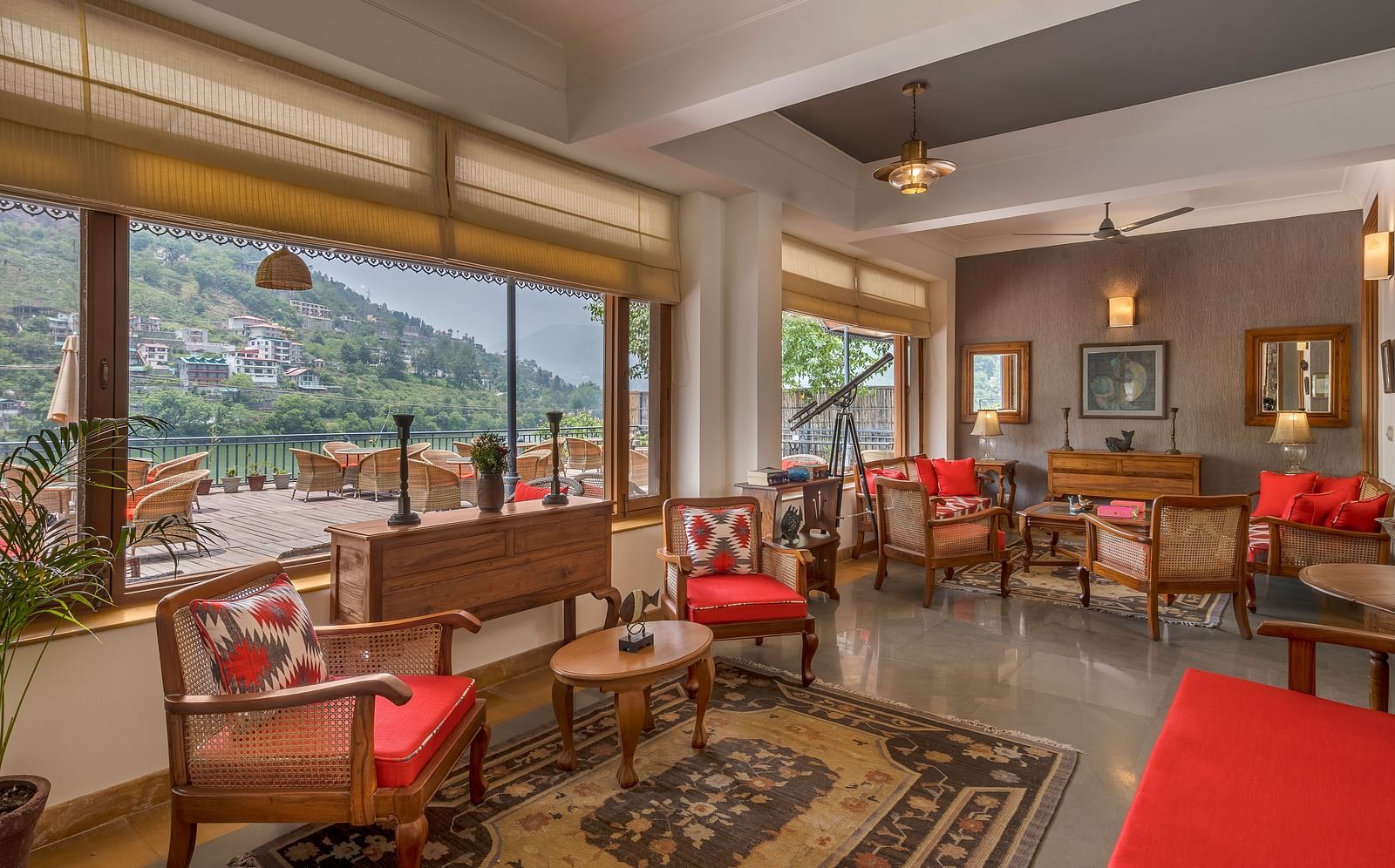 A cozy lounge area featuring comfortable sofas, chairs, and elegant antique interiors, offering stunning views of the lake and mountains from inside Fishermen's Lodge.