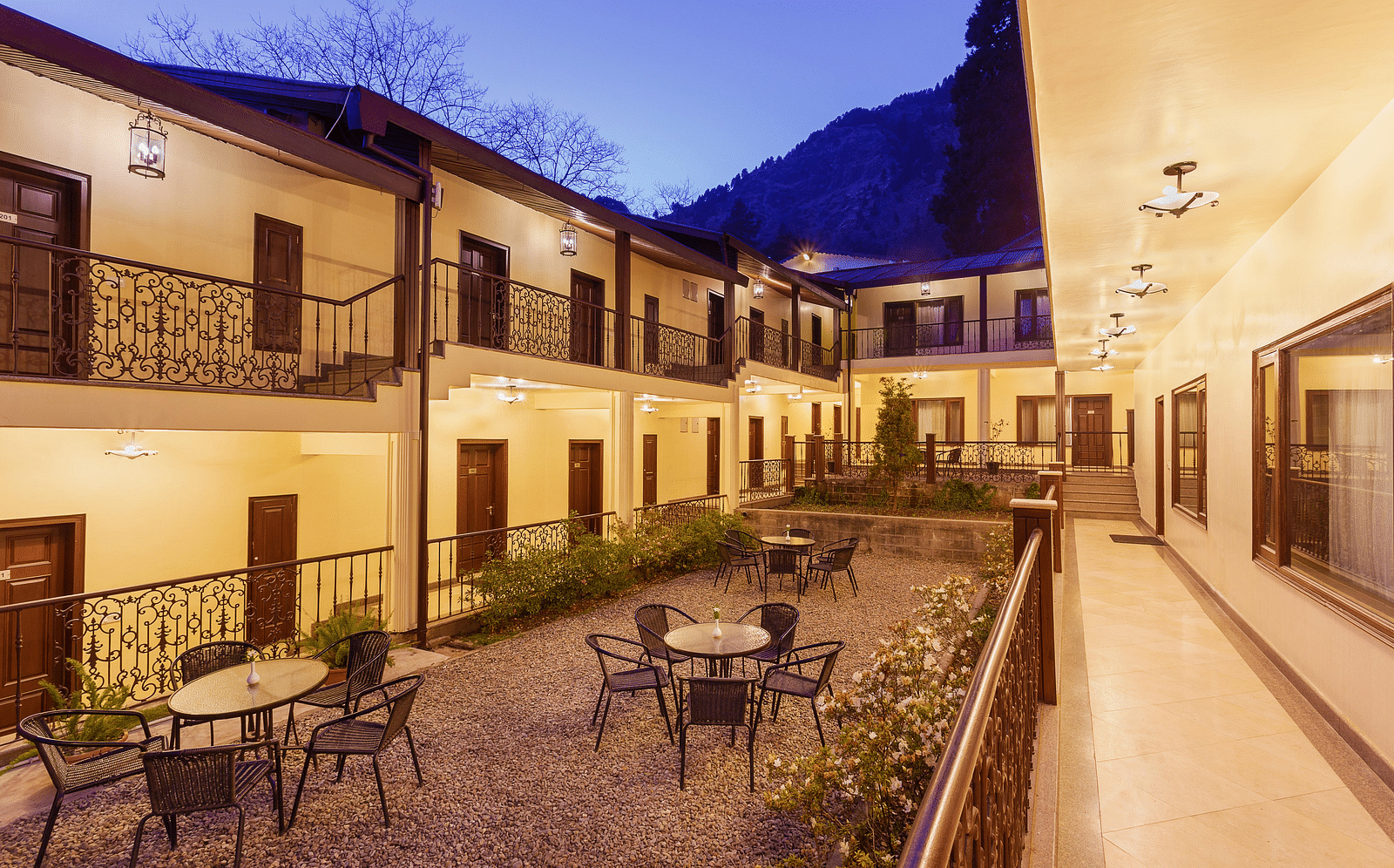 a well lit seating area in the hotel interior with tables with chairs in clusters - The Earl's Court, Nainital