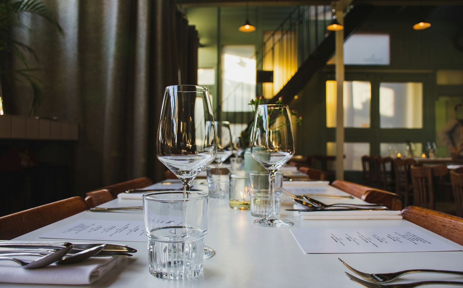 A dining table with wine glass, and half glass of water with cutlery - Nainital