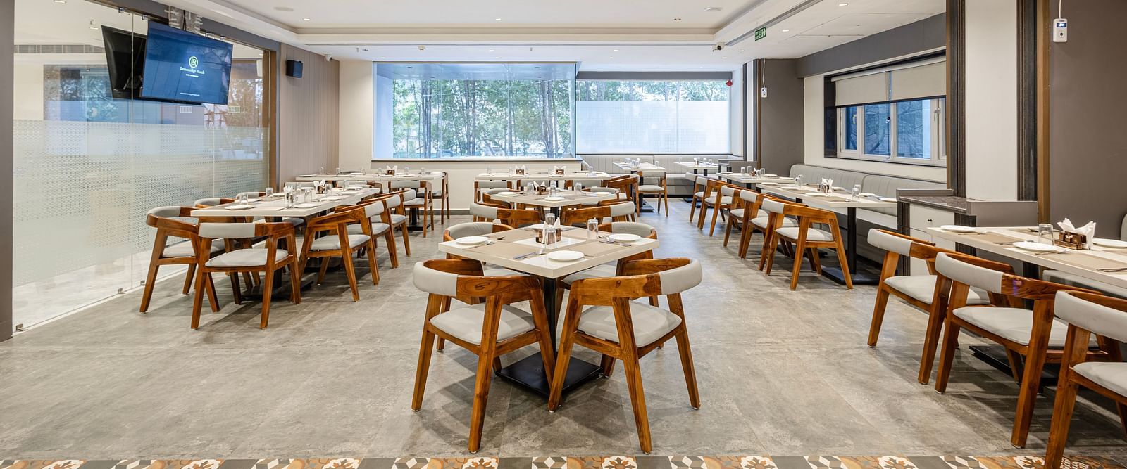 Well-lit restaurant interior showcasing group dining tables at Lemonridge Hotels, IDPL Balanagar.