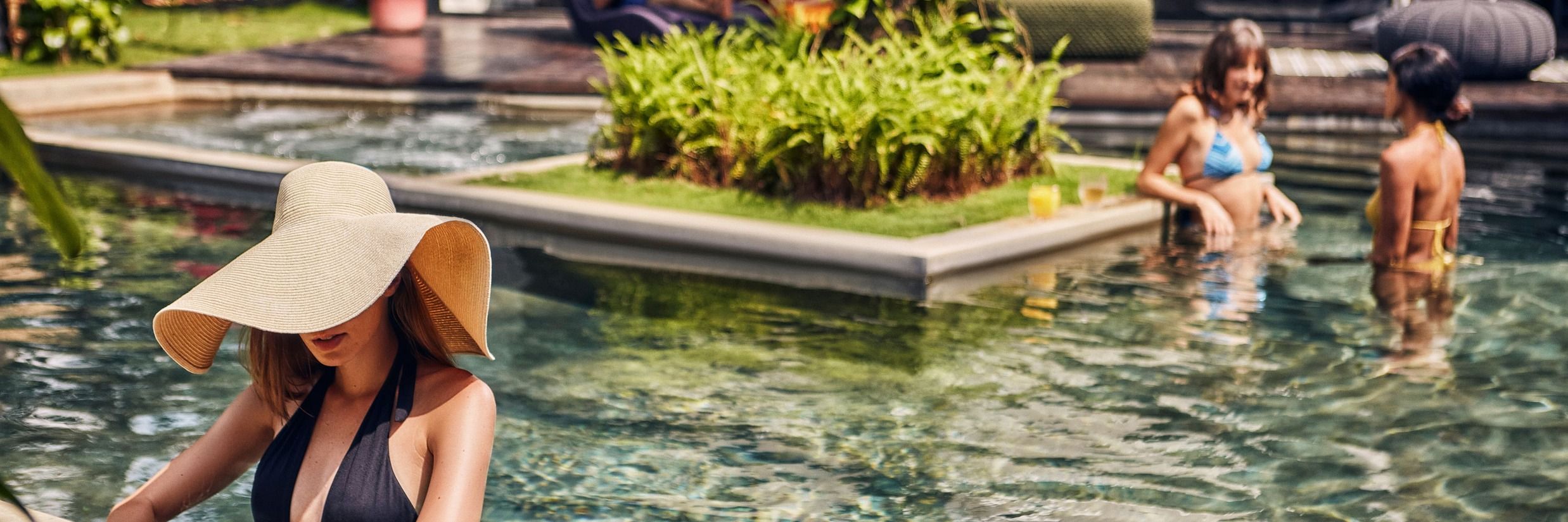 People relaxing in the clear waters of the Goa villa with private pool at V Escapes Sangolda