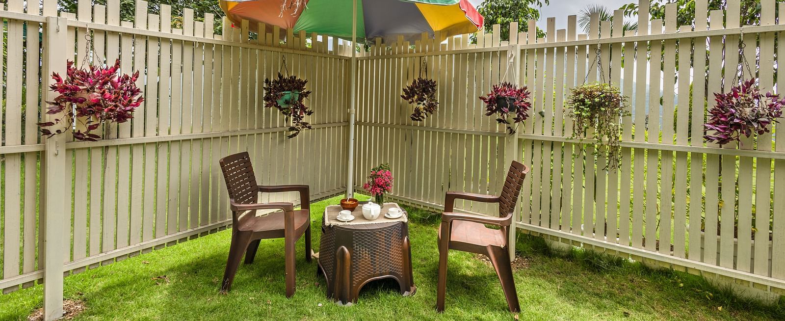 two chairs and a small table in between with a canopy above in a garden area - neer ganga resorts