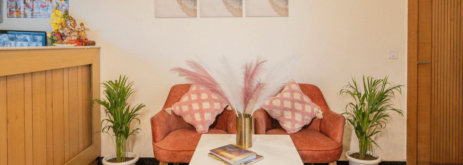 A seating area with chairs, table, and wall art at Perfectstayz Premium at Mall Road Hotel Super, Mussoorie.