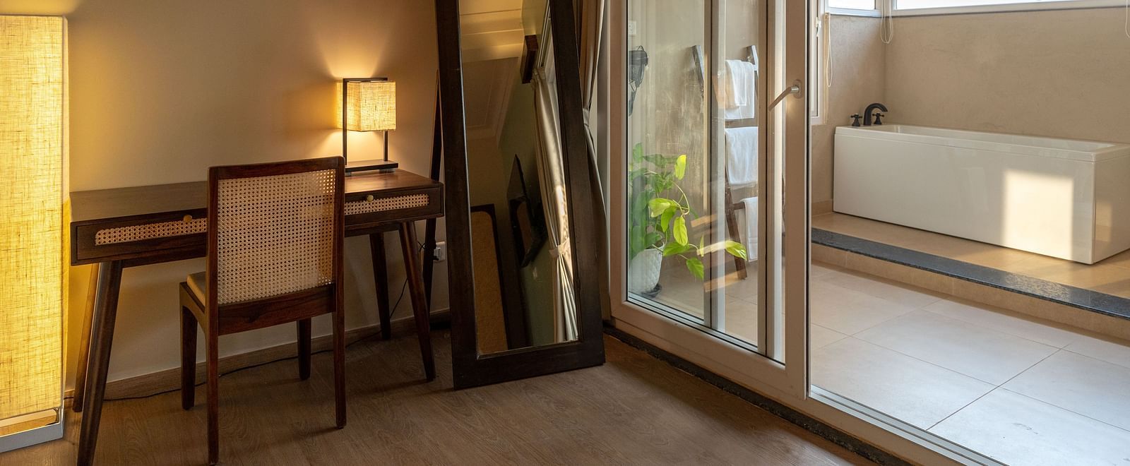 Well-lit room with work desk, mirror, and a view leading to the outdoor bathtub at Kssemya.